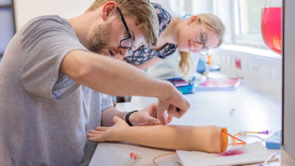 Medizinisches Training an einem Modellarm mit Übung zur Venenpunktion im Skills-Lab der UMCH.